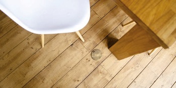 Bodensteckdose im Holzboden an einem Tisch